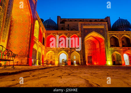 Colorato luminoso atrio di Sher-Dor Madrasah di notte, Samarcanda Registan, Uzbekistan Foto Stock