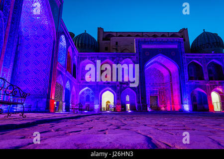 Colorato luminoso atrio di Sher-Dor Madrasah di notte, Samarcanda Registan, Uzbekistan Foto Stock