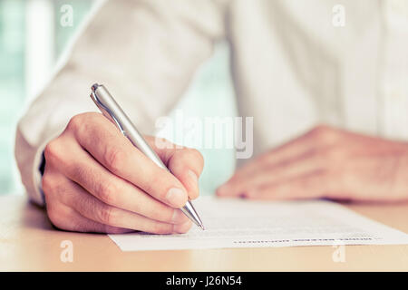 Imprenditore la firma di un documento. Foto oscurata, profondità di campo. Foto Stock