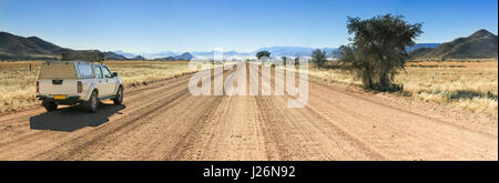 Pickup truck guida veloce sul lungo rettilineo di strada nel deserto Foto Stock