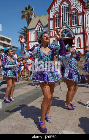 Elementi femmina di un Caporales il gruppo di musica da ballo in costumi ornati di eseguire l'annuale Carnaval Andino con la Fuerza del Sol a Arica, Cile. Foto Stock