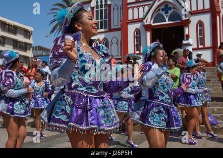 Elementi femmina di un Caporales il gruppo di musica da ballo in costumi ornati di eseguire l'annuale Carnaval Andino con la Fuerza del Sol a Arica, Cile. Foto Stock