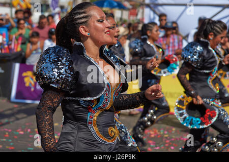 Elementi femmina di un Caporales il gruppo di musica da ballo in costumi ornati di eseguire l'annuale Carnaval Andino con la Fuerza del Sol a Arica, Cile. Foto Stock
