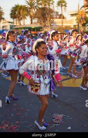 Elementi femmina di un Caporales il gruppo di musica da ballo in costumi ornati di eseguire l'annuale Carnaval Andino con la Fuerza del Sol a Arica, Cile. Foto Stock