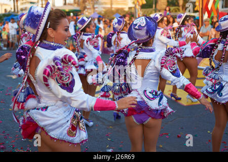 Elementi femmina di un Caporales il gruppo di musica da ballo in costumi ornati di eseguire l'annuale Carnaval Andino con la Fuerza del Sol a Arica, Cile. Foto Stock