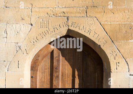 Vecchia scuola di grammatica porta di legno e iscrizione [Scholae grammatica] scolpiti nella pietra arch. Chipping Campden, Cotswolds, Gloucestershire, Inghilterra Foto Stock