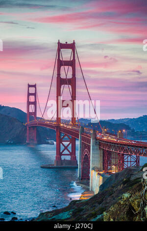 Classic vista panoramica del famoso Golden Gate Bridge visto da scenic Baker Beach in splendida post tramonto crepuscolo con magenta Cielo e nubi al tramonto Foto Stock