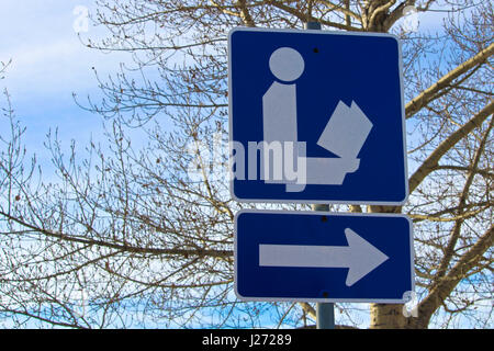 Direzione di cartello Library Sign con albero in background. Foto Stock