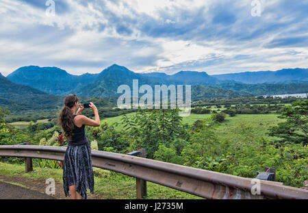 Hanalei Kauai Hawaii donna prendendo video affacciato sulla Baia di Hanalei dal di sopra Foto Stock