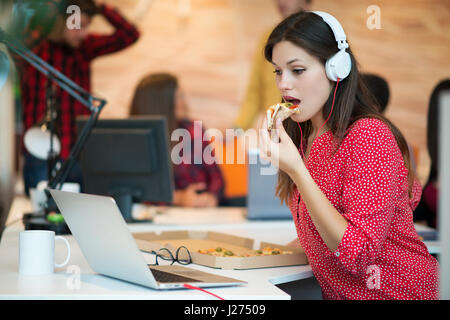 Giovani femmine nel team di call center di mangiare la pizza. Foto Stock