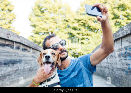 Giovane uomo prende un selfie con il suo cane Foto Stock