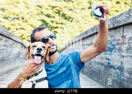 Giovane uomo prende un selfie con il suo cane Foto Stock