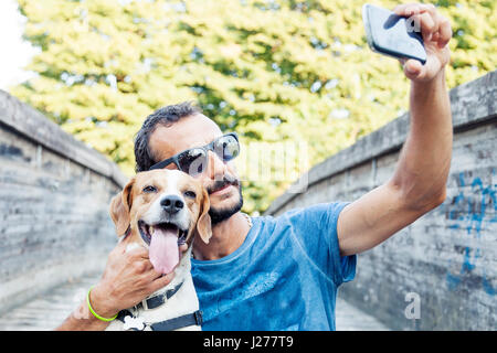 Giovane uomo prende un selfie con il suo cane Foto Stock