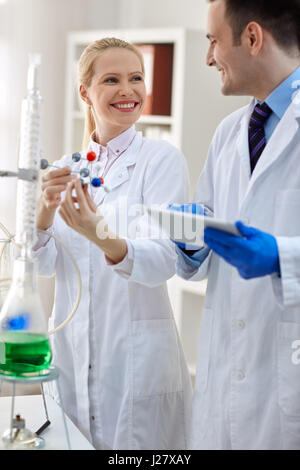 Gruppo di scienziato sorridente analizzando la struttura molecolare in laboratorio Foto Stock