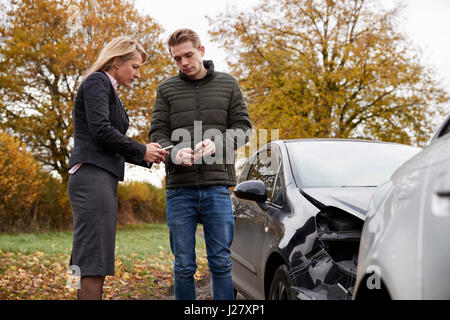 Due driver scambiando i dettagli di assicurazione dopo incidente di automobile Foto Stock