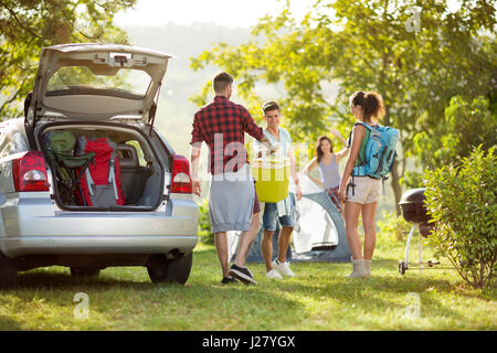 Gli amici di disimballare auto per viaggio di campeggio in campagna Foto Stock