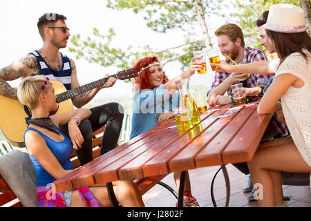 Le ragazze del gruppo di giovani toast con bicchieri di birra Foto Stock