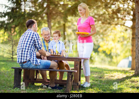 Concetto di famiglia natura e giocare a scacchi Foto Stock