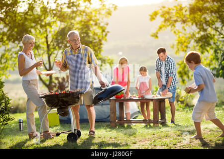 La famiglia felice da campeggio e barbecue per la cottura Foto Stock