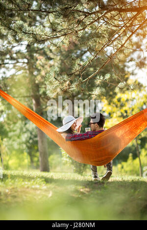 Coppia romantica in amaca fotografato da dietro in foresta Foto Stock