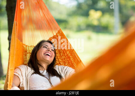 Ragazza allegra godere in arancione amaca all'aperto Foto Stock