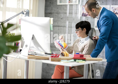 Designer femmina con colleghi di sesso maschile a design studio Foto Stock