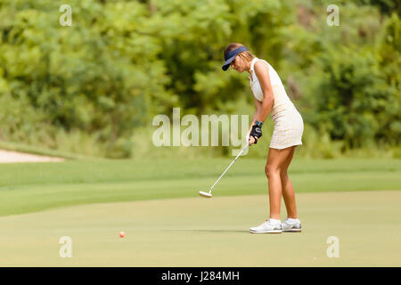 Vista laterale della donna per giocare a golf al campo da golf Foto Stock