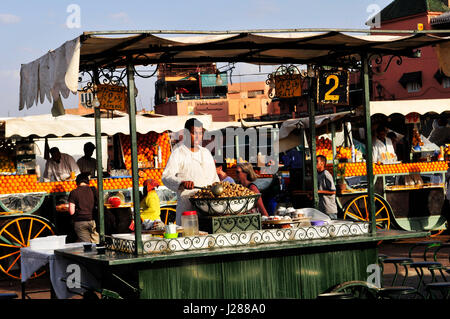 Un babbouche - cotto lentamente le lumache produttore presso la vibrante Djema El Fna sq. in Marrakech, Marocco. Foto Stock