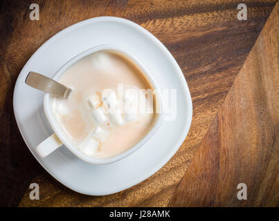 Mattina il cacao con marshmallows in un tavolo di legno. Sfondo scuro. Posto per il testo. Foto Stock