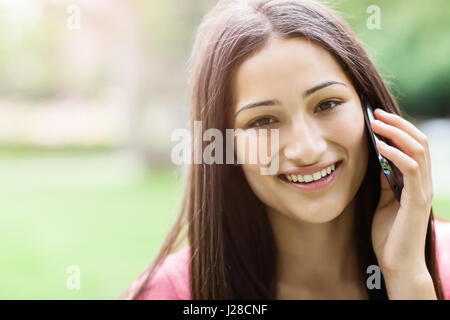 Un colpo di un studente ispanica parlando al telefono Foto Stock