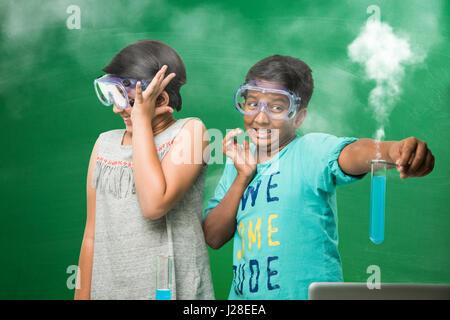Carino bambini indiani fare scienza esperimento in laboratorio di chimica o di biologia lab a scuola Foto Stock