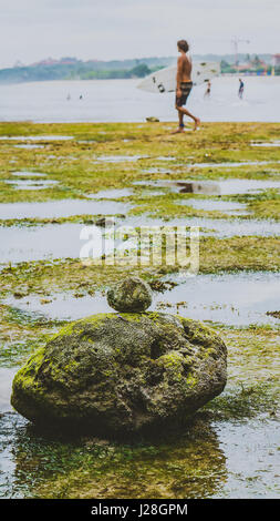 Zen-come pietre ricoperto con Moos sulla spiaggia durante la bassa marea, bella riflessione di acqua, Nusa Dua, Bali, Indonesia Foto Stock