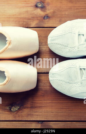 Close up sneakers e pointe shoes su legno Foto Stock