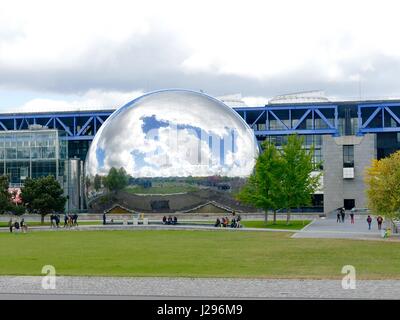 La géode della Cité des Sciences et de l'Industrie presso il Parc de la Villette, XIX Arr., riflette vibrante cielo blu e nuvole pesanti. Parigi, Francia. Foto Stock