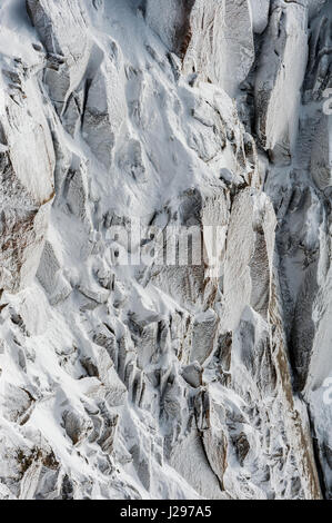 I cristalli di ghiaccio e la superficie trasformata per forte gradiente formato da congelare durante la notte su alta alpine rockface d'inverno. Foto Stock