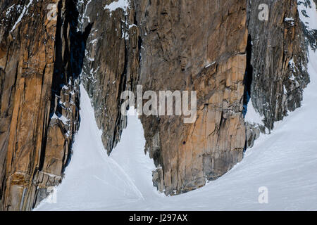 Due alpinisti scalabilità di una grande rockface granito in inverno Foto Stock