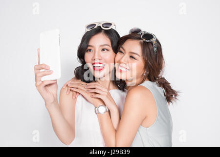 Ritratto di due belle asiatiche donne alla moda tenendo selfie Foto Stock