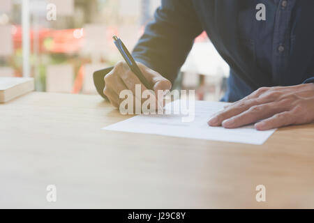 Imprenditore firmano il contratto. Manager firma documento al lavoro. A partire partnership in sede. Foto Stock