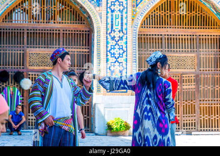 Samarcanda, Uzbekistan - 28 agosto: Ginestra kissing sposa la mano al tradizionale matrimonio uzbeko in Samarcanda Registan. Agosto 2016 Foto Stock