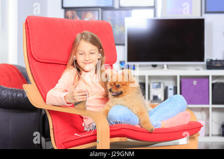 Una ragazza con un cane nella parte anteriore del soggiorno Foto Stock