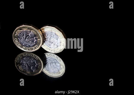 Due nuovi British Pound sterling monete, su un Riflettente superficie nera Foto Stock