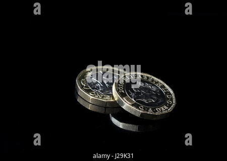Due nuovi British Pound sterling monete, su un Riflettente superficie nera Foto Stock