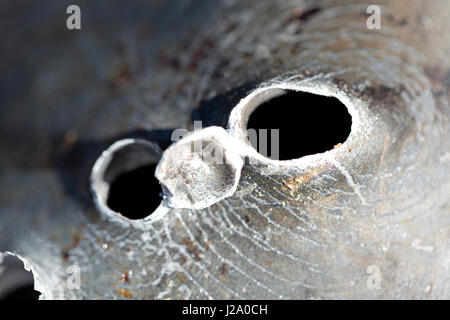 Macro shot di fori di proiettile dopo un tiro al bersaglio in una vaschetta di alluminio. Foto Stock