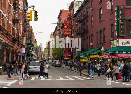 La gente che camminava sul marciapiede e attraversare una strada con edifici e ristoranti, Little Italy, New York, Stati Uniti d'America Foto Stock