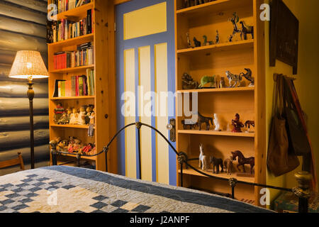 Vista parziale del letto e la pineta di librerie in camera per gli ospiti all'interno di un country cottage in stile residenziale home registro Foto Stock