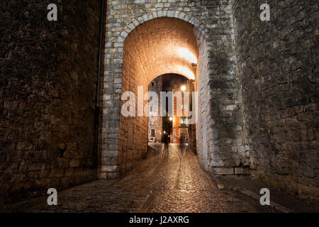 Gate e strada di ciottoli nel centro storico di Girona a notte, Catalogna, Spagna Foto Stock
