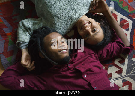 Angolo alto ritratto di affettuosa giovane giacente su un tappeto Foto Stock
