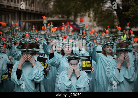 Amnesty International tenere una protesta con 100 'Statues della libertà", per contrassegnare il presidente statunitense Donald Trump's primi cento giorni in ufficio (29 Aprile), davanti all'Ambasciata degli Stati Uniti a Grosvenor Square, Londra. Foto Stock