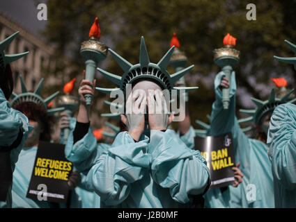 Amnesty International tenere una protesta con 100 'Statues della libertà", per contrassegnare il presidente statunitense Donald Trump's primi cento giorni in ufficio (29 Aprile), davanti all'Ambasciata degli Stati Uniti a Grosvenor Square, Londra. Foto Stock