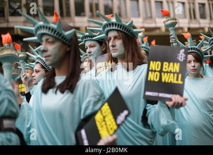 Amnesty International tenere una protesta con 100 'Statues della libertà", per contrassegnare il presidente statunitense Donald Trump's primi cento giorni in ufficio (29 Aprile), davanti all'Ambasciata degli Stati Uniti a Grosvenor Square, Londra. Foto Stock